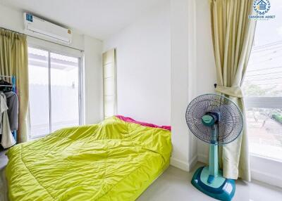 Bright and airy bedroom with large window and electric fan