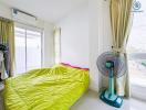 Bright and airy bedroom with large window and electric fan