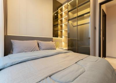 Modern bedroom with a large bed and illuminated built-in wardrobe