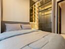 Modern bedroom with a large bed and illuminated built-in wardrobe