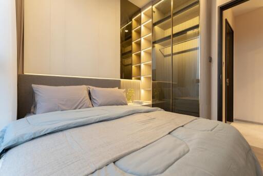 Modern bedroom with a large bed and illuminated built-in wardrobe