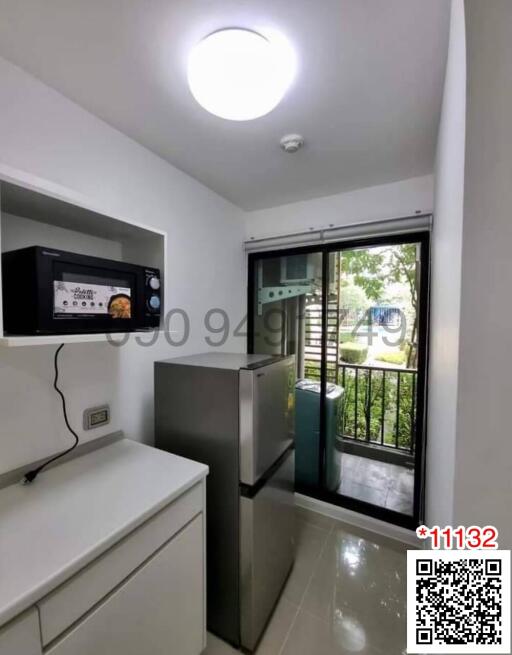 Compact modern kitchen with stainless steel appliances and garden view