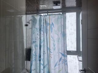 Modern bathroom interior with shower and patterned curtain