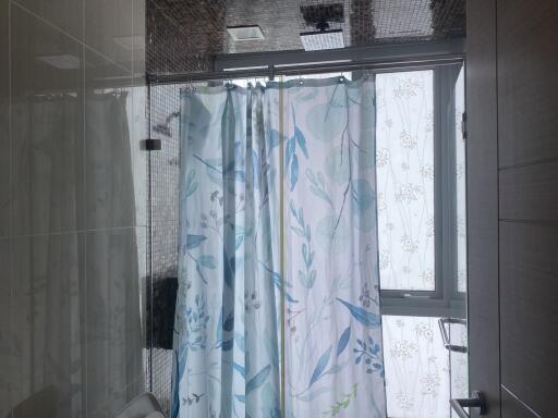 Modern bathroom interior with shower and patterned curtain