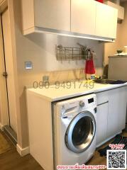 Compact modern kitchen with white cabinetry and built-in washing machine