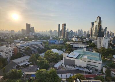 Panoramic cityscape view from a high-rise building at sunset showing an urban skyline