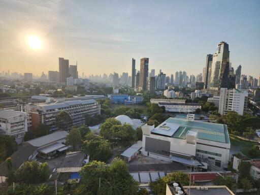 Panoramic cityscape view from a high-rise building at sunset showing an urban skyline