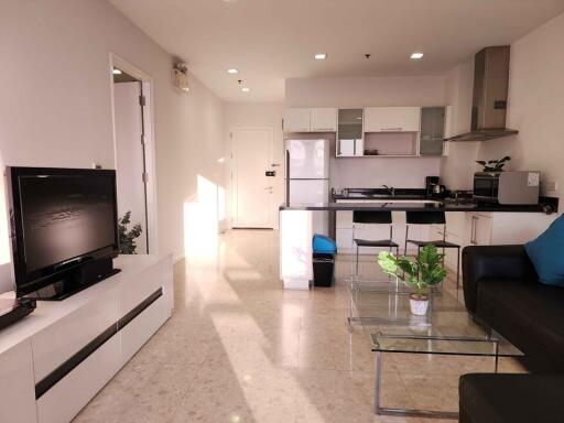 Spacious combined living room and kitchen with modern appliances and ample natural light