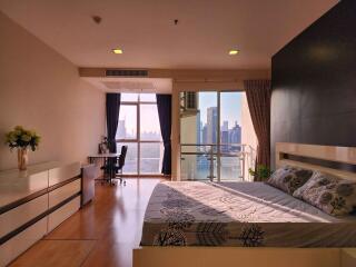 Spacious bedroom with modern design, ample natural light, city view, and office corner