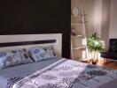 Contemporary bedroom with stylish bedding and a well-lit corner by a shelf