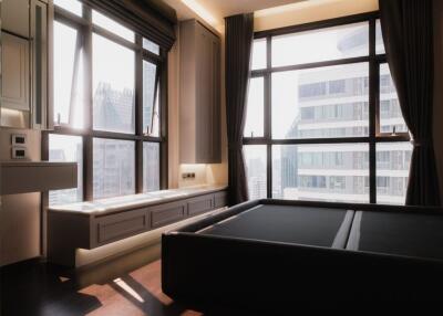 Spacious bedroom with large windows and city view