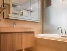 Modern bathroom with wood cabinets and a large mirror