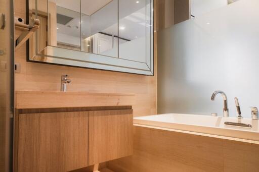 Modern bathroom with wood cabinets and a large mirror