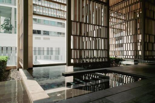 Modern architectural design with wooden latticework and reflective water feature