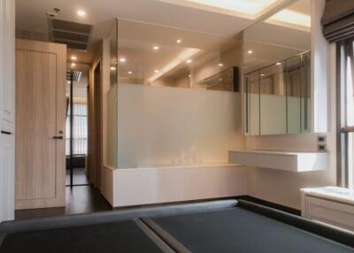 Modern building interior with reflective glass partitions, wooden door, and neutral tones