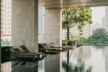 Modern outdoor swimming pool with lounge chairs in a high-rise residential building