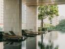 Modern outdoor swimming pool with lounge chairs in a high-rise residential building