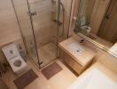 Modern bathroom interior with glass shower and wooden finishes