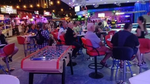 People socializing in a vibrant entertainment area with seating and games