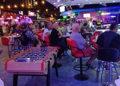 People socializing in a vibrant entertainment area with seating and games