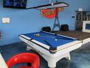 Spacious recreation room with pool table, blue walls and French motifs