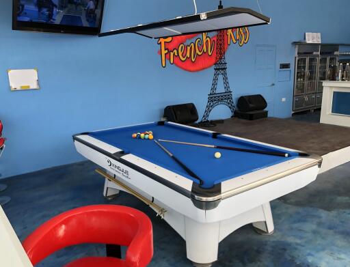 Spacious recreation room with pool table, blue walls and French motifs