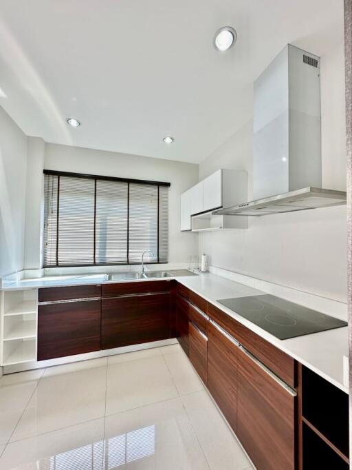 Modern kitchen with white walls, dark cabinets, and stainless steel appliances