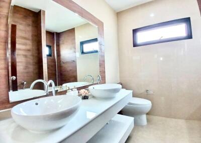 Modern bathroom with dual sinks and wooden accents