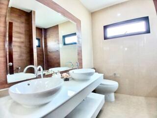 Modern bathroom with dual sinks and wooden accents