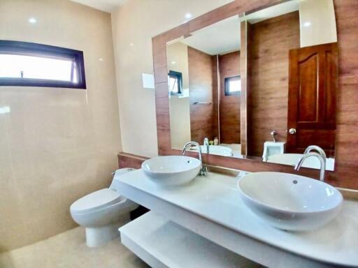 Modern bathroom with dual sinks and wooden accents