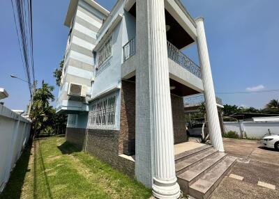 Exterior view of a modern two-story building with columns and parking space