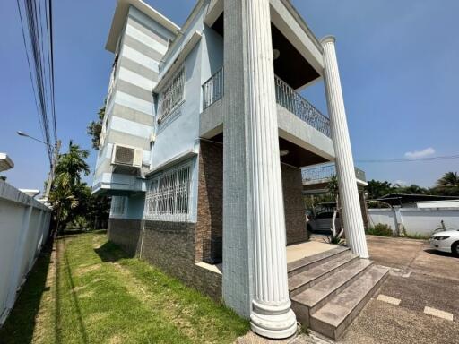 Exterior view of a modern two-story building with columns and parking space