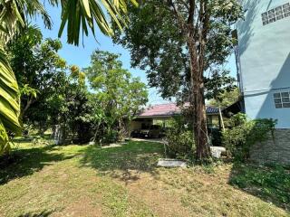 Cozy house with lush garden and carport under sunny blue skies