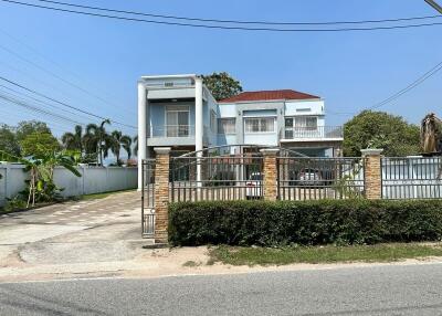 Contemporary two-story residential home with secured gate and balcony