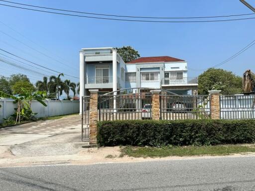 Contemporary two-story residential home with secured gate and balcony