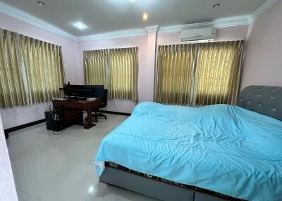 Spacious bedroom with a large bed, piano, and air conditioning