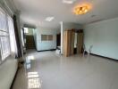 Spacious and well-lit living room with staircase and tile flooring