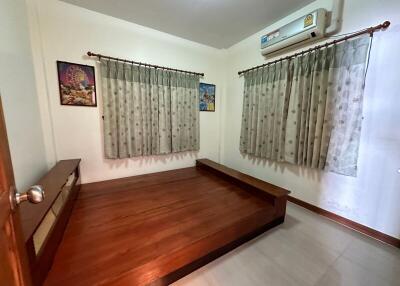 Spacious Bedroom with Wooden Bed Frame and Air Conditioning