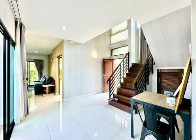 Bright and spacious living room with staircase and glossy floor