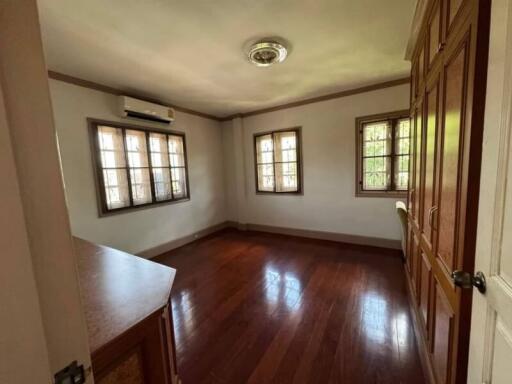 Spacious bedroom with natural light and hardwood floors