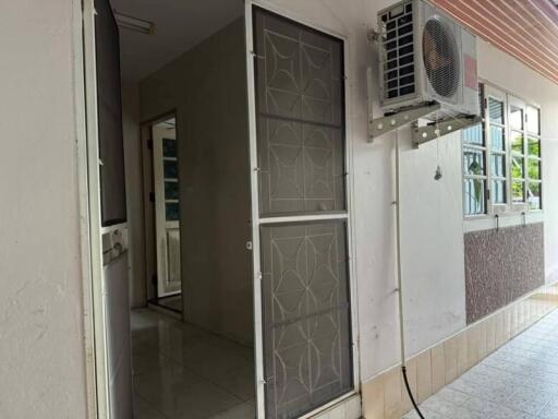 Entrance to a residential building with security door and air conditioning unit