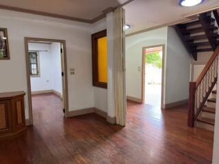 Spacious entryway in a residential home with wooden flooring and staircase