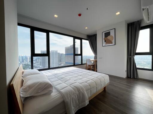 Modern bedroom with large windows and city view