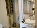 Modern bathroom interior with wooden shelving, glass shower, and white sink