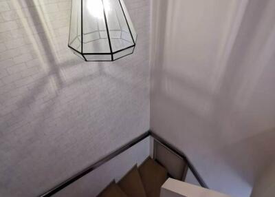 Staircase with white brick wall and hanging pendant light