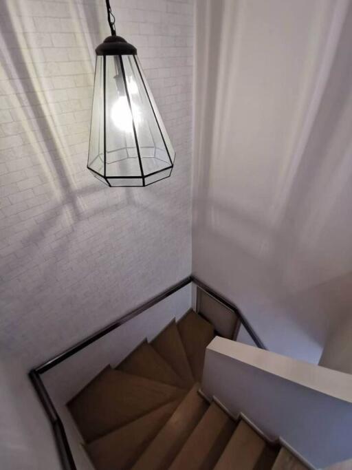 Staircase with white brick wall and hanging pendant light