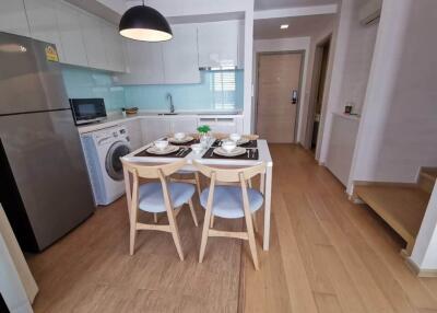 Modern kitchen with dining area, equipped with appliances and wooden flooring