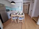 Modern kitchen with dining area, equipped with appliances and wooden flooring