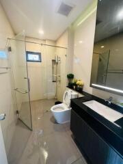 Modern bathroom with glass shower enclosure, toilet and vanity