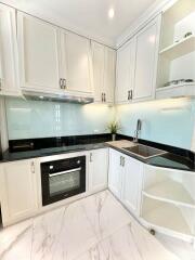 Modern kitchen with white cabinets and marble flooring